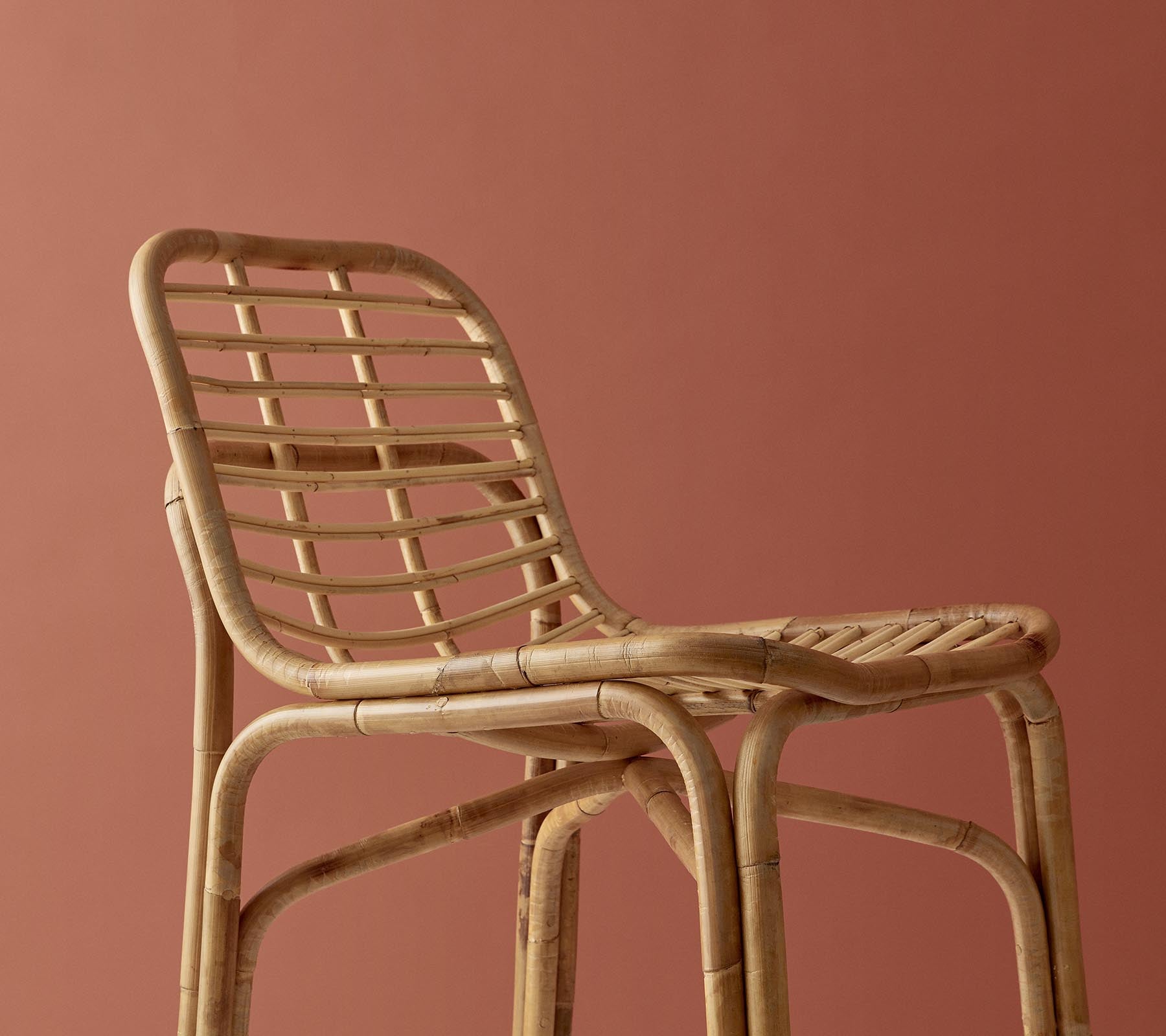 Stylish woven chair in a natural finish, featuring a minimalist design against a muted background.