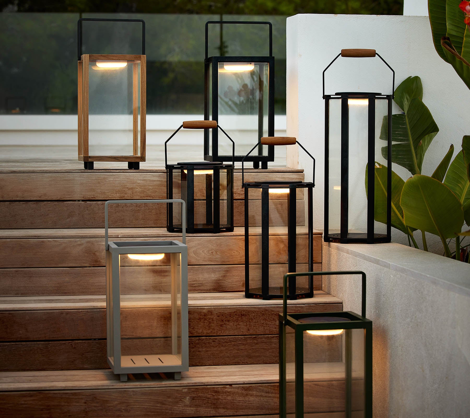 A collection of modern lanterns in various styles and colors arranged on a staircase, highlighting their elegant design and warm illumination.